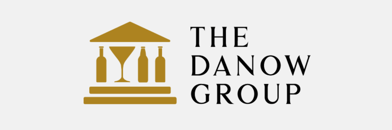 Logo for The Danow Group, a website brand, features a gold building outline with bottles and a martini glass, alongside the company name in black text on a white background.