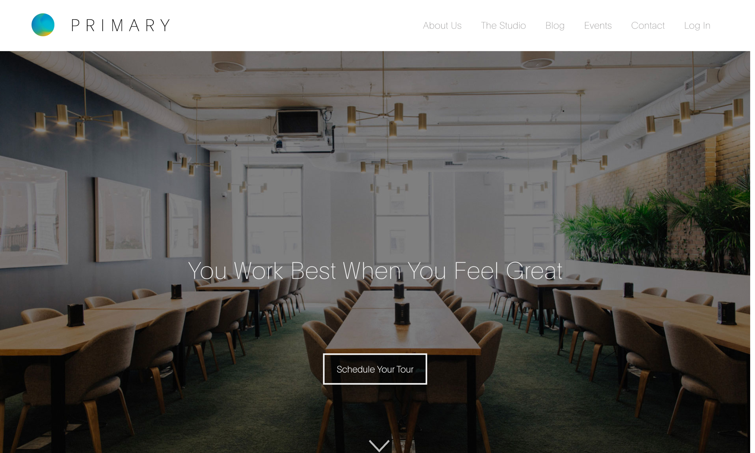 Modern coworking space with long wooden tables, cushioned chairs, hanging lights, and indoor plants; website menu and “Schedule Your Tour” button visible.