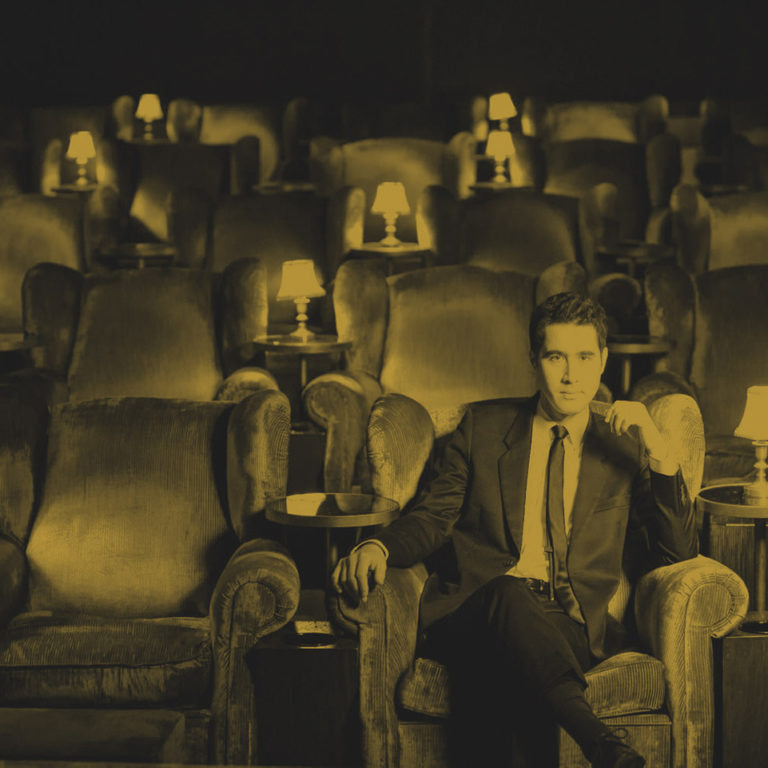 man sitting in an old time fancy movie theater