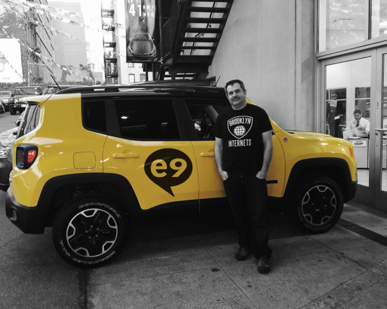 Conrad, founder of e9digital standing next to yellow e9 car
