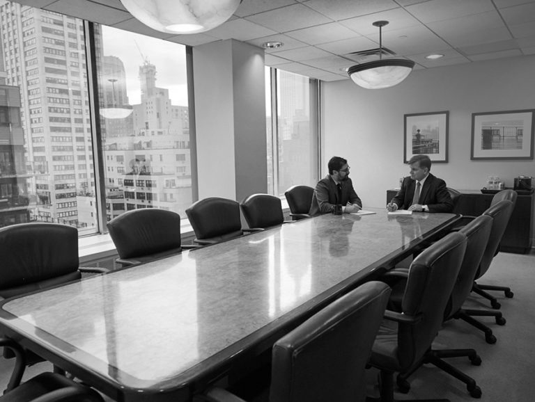 two men speaking in a boardroom