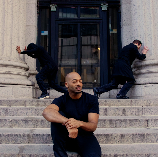 man sitting on steps with two men stretching behind him