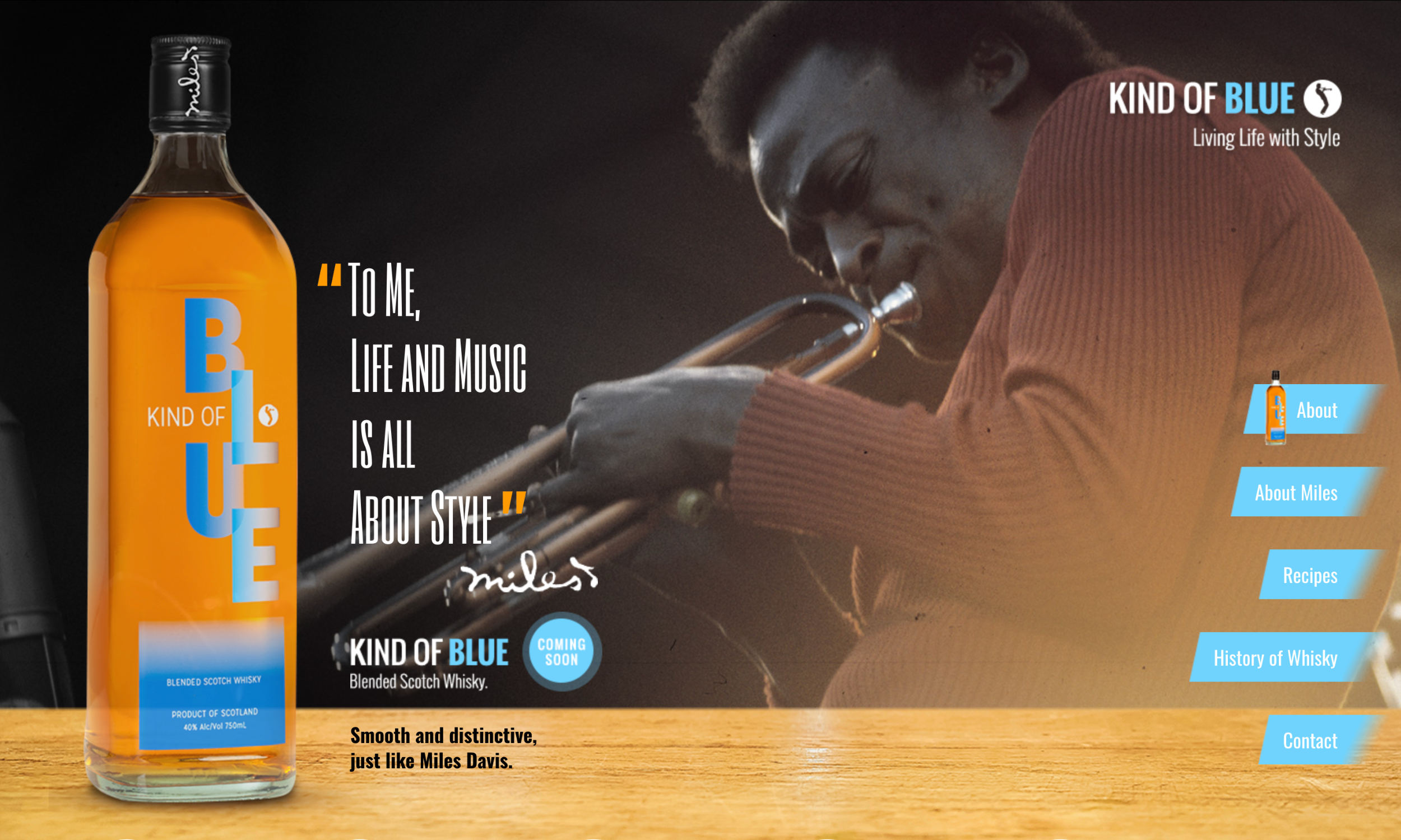 A bottle of Kind of Blue whisky sits on a wooden surface, framed by a distinct web design featuring a black-and-white photo of a man playing trumpet in the background and navigation menu items on the right.