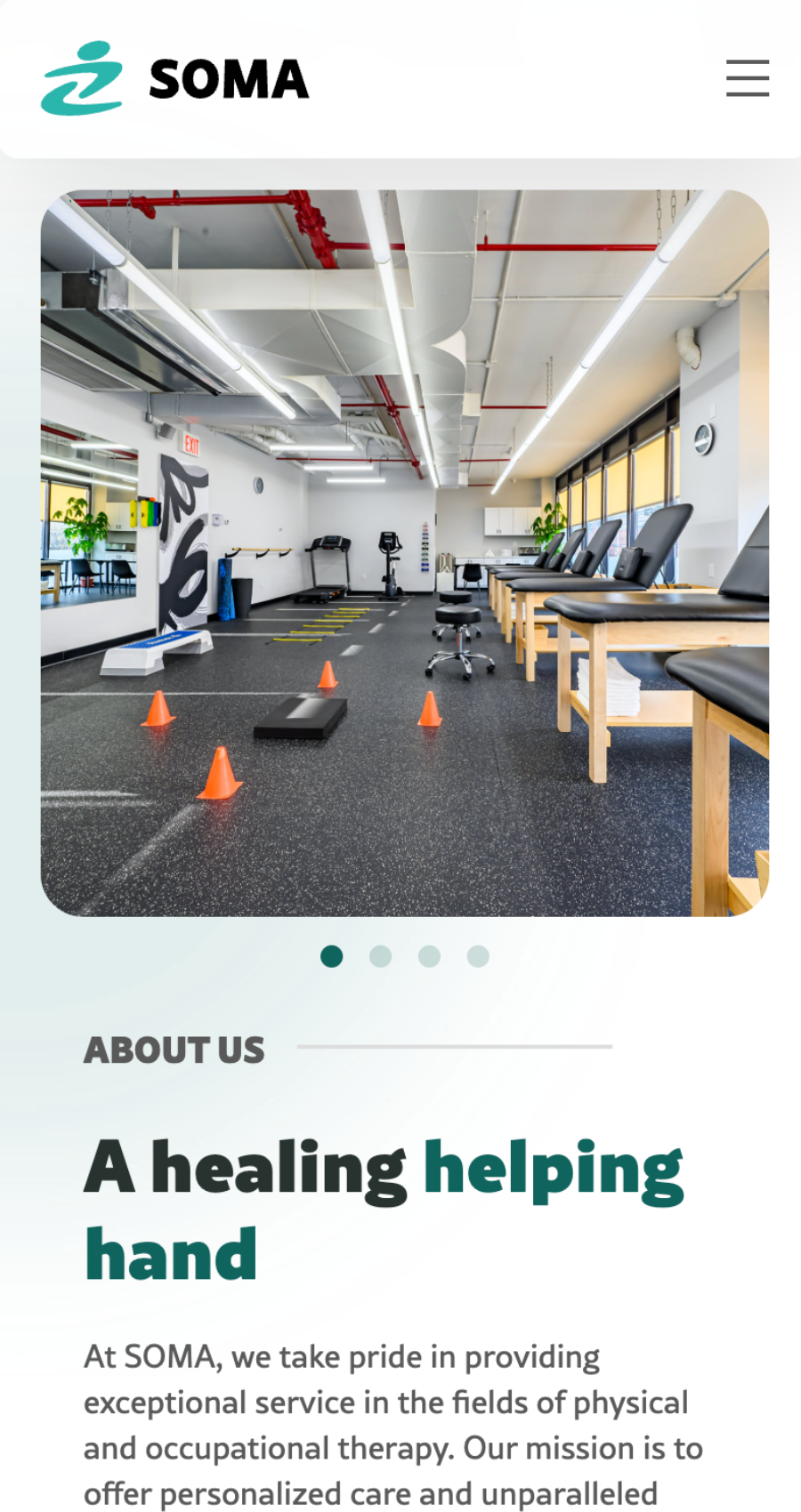 Wide-angle view of Soma Physical Therapy clinic with exercise equipment, therapy tables, and bright lighting.