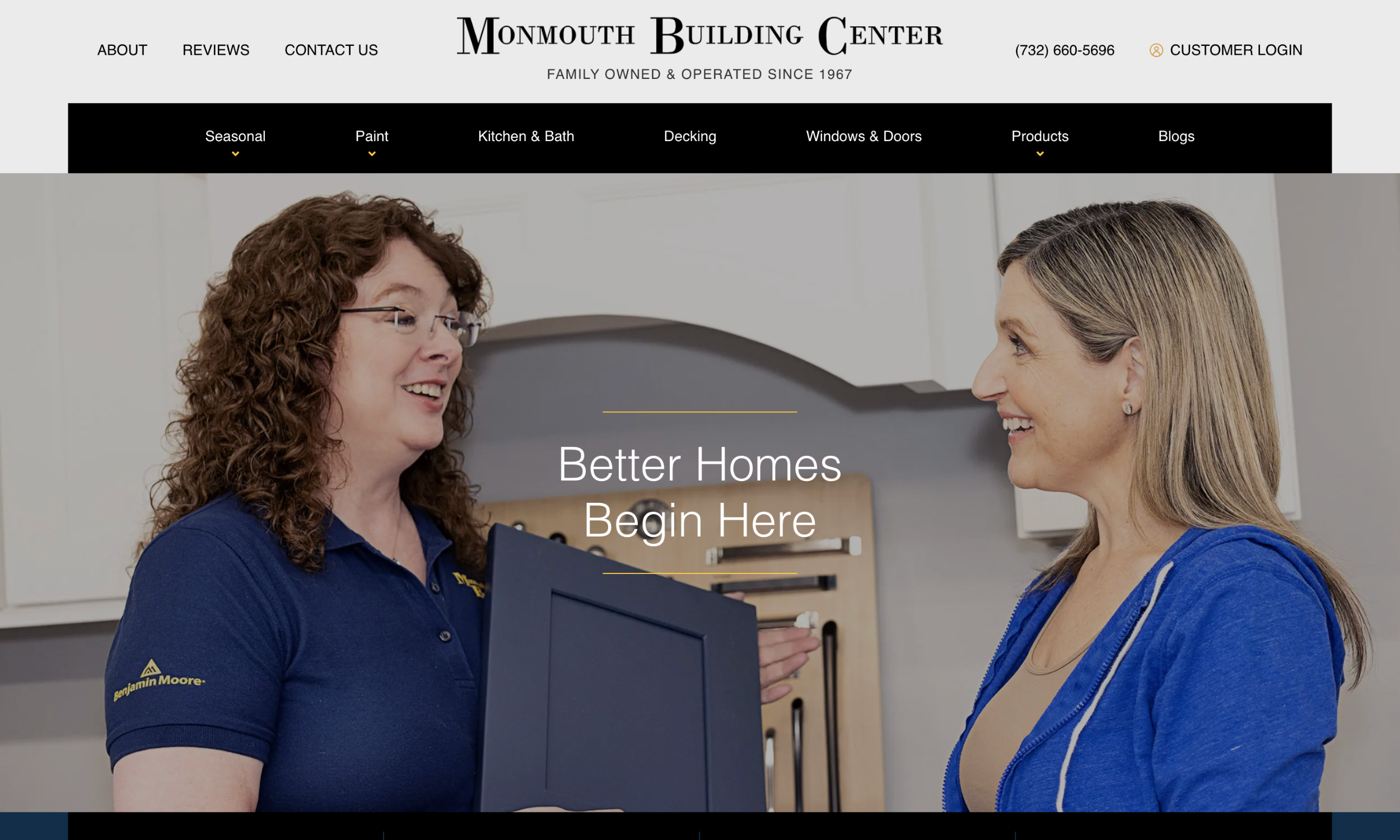 Two women stand in a modern kitchen, one wearing a Monmouth Building Center shirt and holding a folder, engaged in conversation. Text reads "Better Homes Begin Here." Start your dream project with Monmouth Building Center.