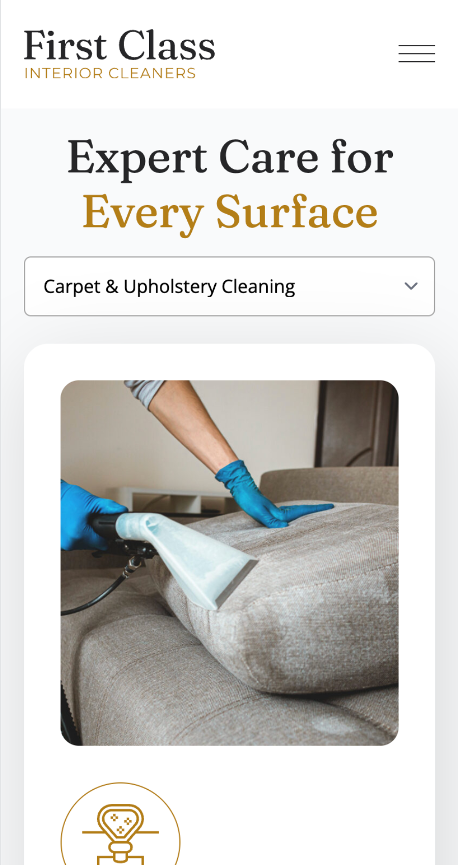 A person wearing blue gloves uses a vacuum cleaner to clean a gray upholstered sofa cushion, showcasing professional standards ideal for a carpet cleaning website design.