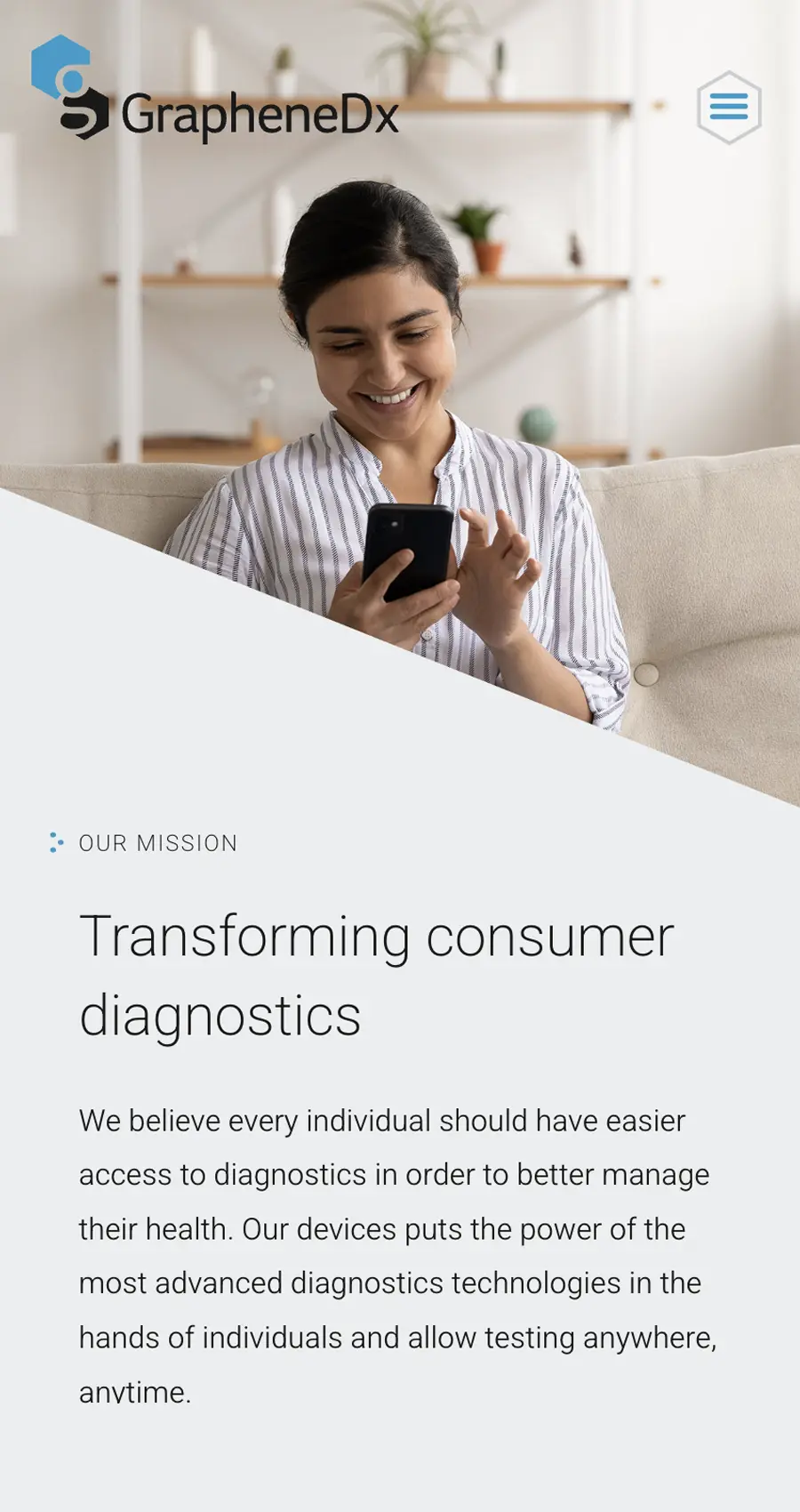 A woman sits on a couch smiling at her smartphone. Text below describes GrapheneDx's mission to enhance consumer diagnostics through advanced devices.