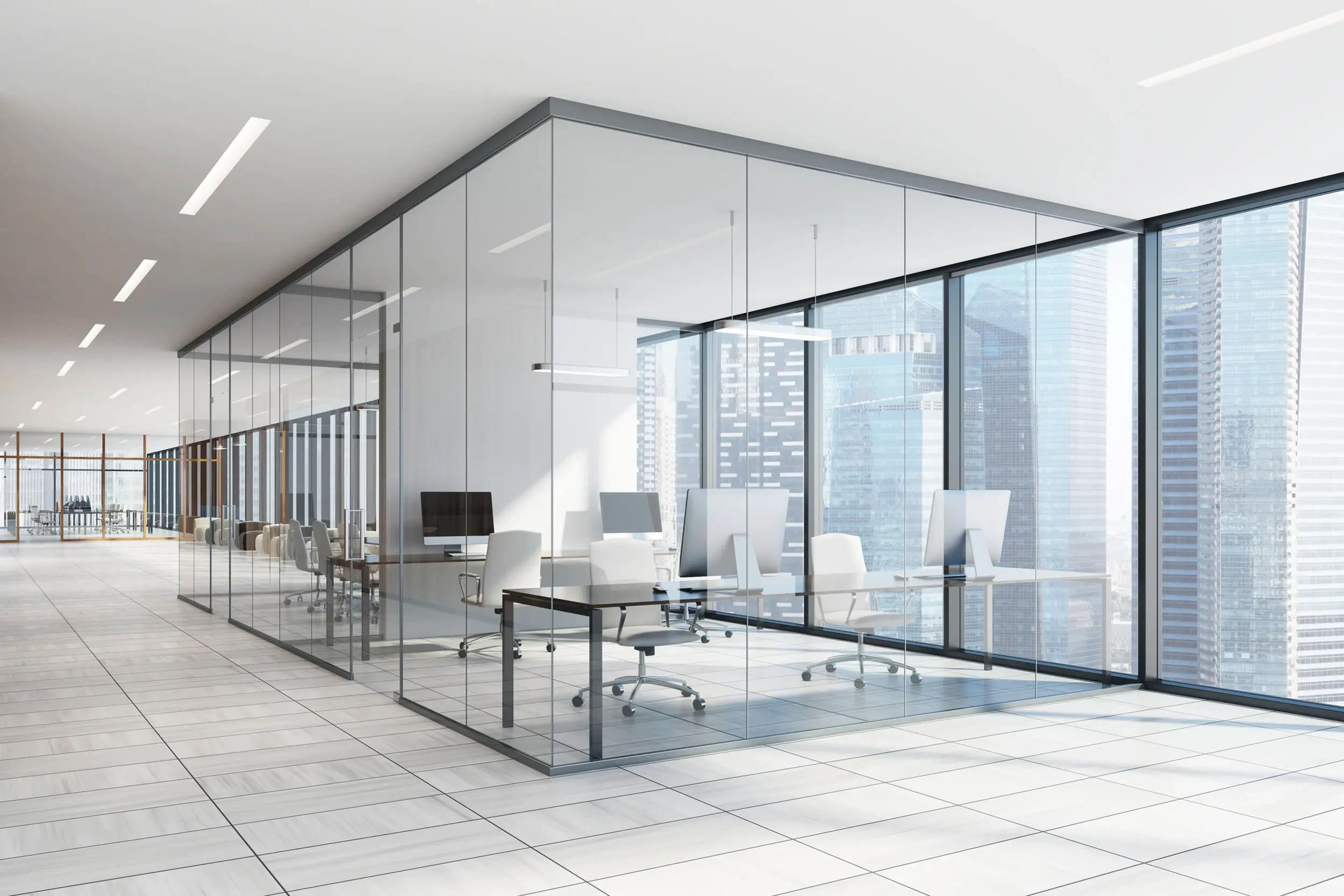Modern office with glass-walled meeting rooms, white desks, office chairs, and desktop computers, overlooking city skyscrapers through large windows.